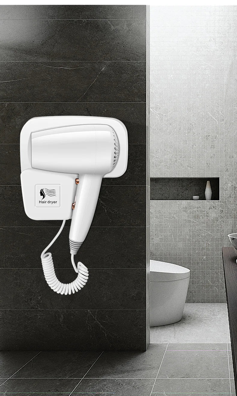 White 1300W wall-mounted hair dryer with coiled cord, ideal for hotel or home bathrooms. Fast-drying, space-saving unit.