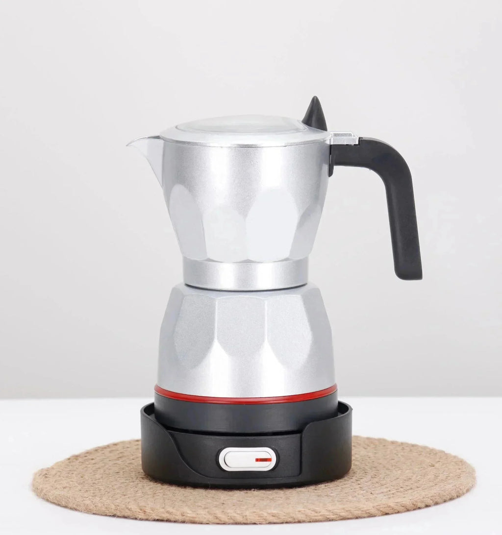 Silver aluminum electric moka pot coffee maker with black handle and base on a jute mat.