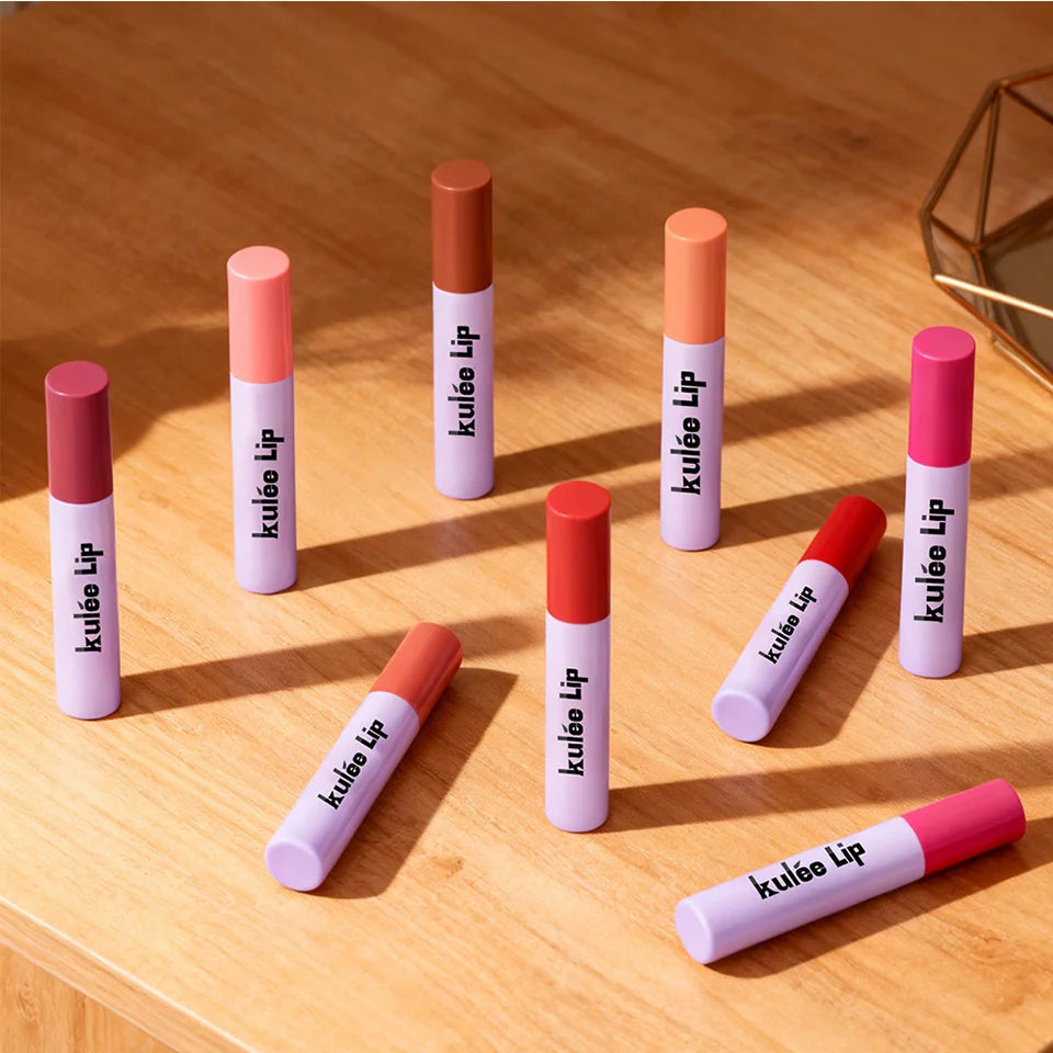 Collection of Kulfée long-lasting lip oil stain tubes in various vibrant shades on a wooden surface.