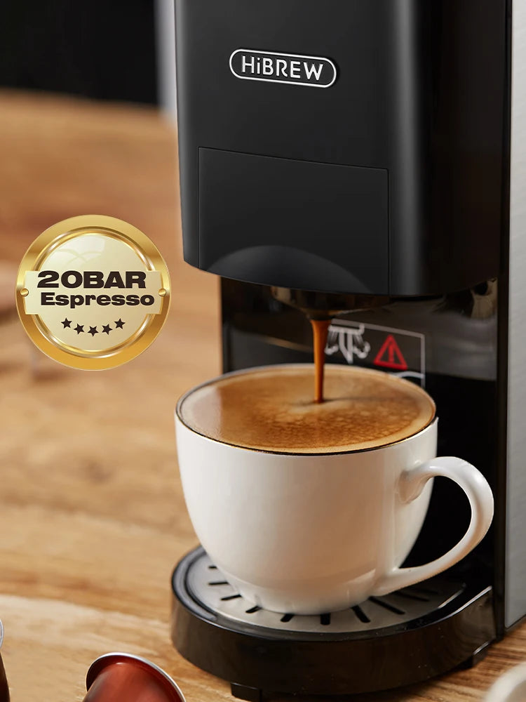 HiBREW 20-bar espresso machine in black brewing coffee into a white cup on a wooden surface.
