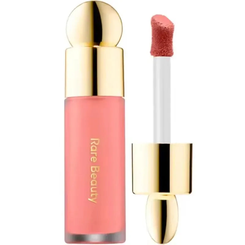 Rare Beauty matte lip makeup in a coral shade with a smooth, moisturizing texture and elegant gold applicator wand.