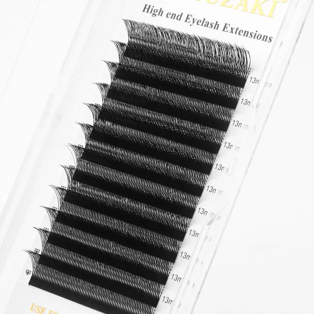 Tray of black, C-curl eyelash extensions, 13mm length, arranged in rows on a clear adhesive strip for application.