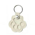 White leather pet hair storage keychain with cat paw design, perfect as a portable memorial bag pendant.